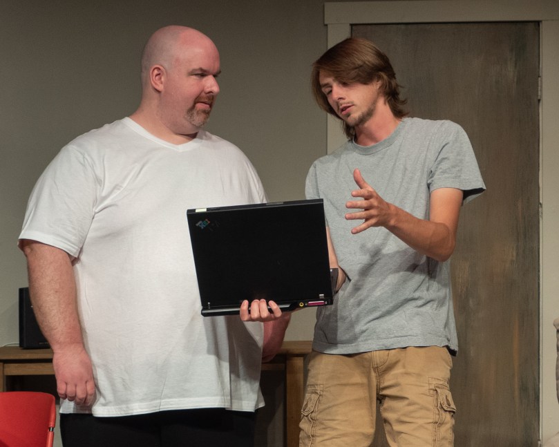 Two actors looking at a laptop screen.